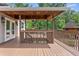 An outdoor wooden deck featuring an area with a covered ceiling and stairs down to a lower level at 12085 Stringer Rd, Brooksville, FL 34601
