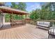 Spacious wooden deck featuring an outdoor seating area and a view of the surrounding greenery at 12085 Stringer Rd, Brooksville, FL 34601