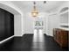 Elegant dining room boasts black tile floor, decorative chandelier, and view to the lanai at 12085 Stringer Rd, Brooksville, FL 34601