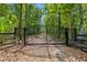Gated property entrance with long driveway to a partially visible home at 12085 Stringer Rd, Brooksville, FL 34601