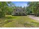 Inviting two-story home with a balcony, well-manicured lawn, and surrounded by lush greenery at 12085 Stringer Rd, Brooksville, FL 34601
