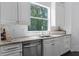 Bright kitchen with stainless steel appliances, a dual sink, a picture window, and custom cabinetry at 12085 Stringer Rd, Brooksville, FL 34601