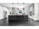 Modern kitchen with a large island, stainless steel appliances, and sleek black tile flooring at 12085 Stringer Rd, Brooksville, FL 34601