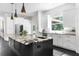 A modern kitchen with an island, stainless steel appliances, custom cabinetry, and hardwood floors at 12085 Stringer Rd, Brooksville, FL 34601