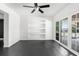 Living room featuring a ceiling fan, built-in shelves, and sliding glass doors to the backyard at 12085 Stringer Rd, Brooksville, FL 34601