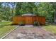 Exterior of a wooden outbuilding with a gabled roof surrounded by lush greenery at 12085 Stringer Rd, Brooksville, FL 34601