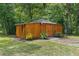 Exterior of a wooden outbuilding with a gabled roof surrounded by lush greenery at 12085 Stringer Rd, Brooksville, FL 34601