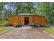 Exterior of wooden outbuilding featuring a gabled roof and sliding doors, surrounded by plants at 12085 Stringer Rd, Brooksville, FL 34601