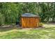 Unique wooden outbuilding nestled among lush trees with a well-kept lawn at 12085 Stringer Rd, Brooksville, FL 34601