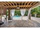 Inviting outdoor patio with exposed wood beam ceiling, elegant curtains, and stylish pavers at 12085 Stringer Rd, Brooksville, FL 34601