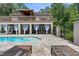 Relaxing poolside with lounge chairs on a brick patio and an elegant home exterior at 12085 Stringer Rd, Brooksville, FL 34601