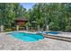 Backyard pool and spa surrounded by stone pavers, professional landscaping, and privacy fence at 12085 Stringer Rd, Brooksville, FL 34601