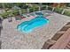 Aerial view of a private backyard swimming pool and hot tub surrounded by a brick-paved patio at 12085 Stringer Rd, Brooksville, FL 34601