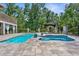 Backyard pool and spa surrounded by stone pavers, professional landscaping, and privacy fence at 12085 Stringer Rd, Brooksville, FL 34601