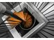 Aerial view of a modern spiral staircase with black metal railings and wood treads at 12085 Stringer Rd, Brooksville, FL 34601