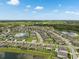 Overhead aerial view of residential community featuring homes by a lake with lush green landscapes at 12313 Criollo Rd, Spring Hill, FL 34610