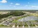 Extensive aerial view of a residential community with homes surrounding a scenic lake and wooded areas at 12313 Criollo Rd, Spring Hill, FL 34610