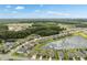 Expansive aerial perspective of a residential area featuring homes around a large lake and lush green landscape at 12313 Criollo Rd, Spring Hill, FL 34610