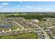 Broad aerial view of houses in a lakeside neighborhood with lush green spaces, perfect for community living at 12313 Criollo Rd, Spring Hill, FL 34610