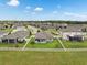A birds-eye view shows a manicured backyard, verdant lawn, screened patio, and white picket fence at 12313 Criollo Rd, Spring Hill, FL 34610