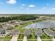 Aerial view featuring homes in a lakeside community surrounded by lush greenery and serene water views at 12313 Criollo Rd, Spring Hill, FL 34610