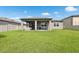 View of the backyard with a covered patio and well-maintained lawn perfect for outdoor relaxation and entertainment at 12313 Criollo Rd, Spring Hill, FL 34610