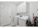 Functional laundry room with a washer and dryer, storage cabinets and a door to the rest of the home at 12313 Criollo Rd, Spring Hill, FL 34610