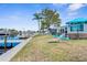 Spacious backyard with a waterfront view, featuring outdoor seating, a patio, and lush landscaping at 12535 Third Isle, Hudson, FL 34667