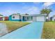 Charming single-story home with a blue driveway and unique architectural details at 12535 Third Isle, Hudson, FL 34667