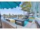 Inviting outdoor patio featuring comfortable wicker furniture, a picnic table, and a grill, perfect for entertaining by the water at 12535 Third Isle, Hudson, FL 34667