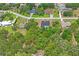 Aerial view of the home showing the landscaping, pool, and the wooded neighborhood setting at 128 Oak Lake Dr, Spring Hill, FL 34608