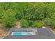 Aerial view of a pool with a screen enclosure, surrounded by dense trees and offering a private outdoor retreat at 128 Oak Lake Dr, Spring Hill, FL 34608