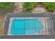 Aerial view of a screened-in pool providing a clear view of its rectangular shape, surrounding patio, and lush greenery at 128 Oak Lake Dr, Spring Hill, FL 34608