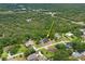 Aerial view of house and lot, surrounded by many trees and other residential homes at 128 Oak Lake Dr, Spring Hill, FL 34608