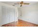 Bedroom with hard wood flooring and double closet features a ceiling fan at 128 Oak Lake Dr, Spring Hill, FL 34608