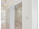 Walk-in closet with white shelving and door, adjacent to hallway and bathroom at 128 Oak Lake Dr, Spring Hill, FL 34608