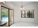Dining room featuring tile floors, a chandelier, a large window, and sliding glass doors to the pool area at 128 Oak Lake Dr, Spring Hill, FL 34608