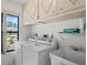 Bright laundry room equipped with washer, dryer, utility sink, and storage cabinets at 128 Oak Lake Dr, Spring Hill, FL 34608