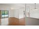 Open-concept living room with hardwood floors and sliding glass doors to the pool area at 128 Oak Lake Dr, Spring Hill, FL 34608