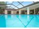 Large screened-in pool with crystal-clear water, providing a refreshing oasis for swimming and leisure in a private backyard at 128 Oak Lake Dr, Spring Hill, FL 34608