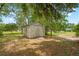 Quaint backyard shed offering additional storage, nestled among trees and lush foliage for a charming, functional space at 128 Oak Lake Dr, Spring Hill, FL 34608