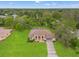 An aerial view showcasing the home's well-manicured lawn, mature trees, and inviting pool area at 12805 Coronado Dr, Spring Hill, FL 34609