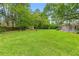 Lush backyard featuring a well-maintained lawn, mature trees, and a storage shed at 12805 Coronado Dr, Spring Hill, FL 34609