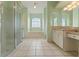 Bathroom featuring a glass-enclosed shower, soaking tub, and a double vanity with great natural light at 12805 Coronado Dr, Spring Hill, FL 34609