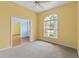 Bright bedroom with carpet, fan, and a view towards front entrance and living areas at 12805 Coronado Dr, Spring Hill, FL 34609