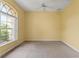Comfortable bedroom with carpet flooring, ceiling fan, and a large arched window at 12805 Coronado Dr, Spring Hill, FL 34609