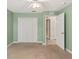 A green carpeted bedroom features a closet and a doorway to the rest of the house at 12805 Coronado Dr, Spring Hill, FL 34609
