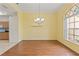 Dining room featuring hardwood floors, a stylish chandelier, and natural light from an arched window at 12805 Coronado Dr, Spring Hill, FL 34609