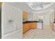 Bright kitchen with granite countertops, wooden cabinets, tile floors, and a water-dispensing refrigerator at 12805 Coronado Dr, Spring Hill, FL 34609