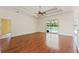 Spacious living room features gleaming hardwood floors and a sliding glass door with a view of the pool at 12805 Coronado Dr, Spring Hill, FL 34609